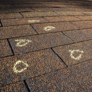 Insurance Adjuster marked hail damage on a insureds roof.